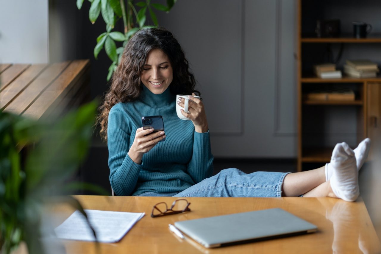 Remote worker girl procrastinate at workplace sit at desk with closed laptop chat in social media